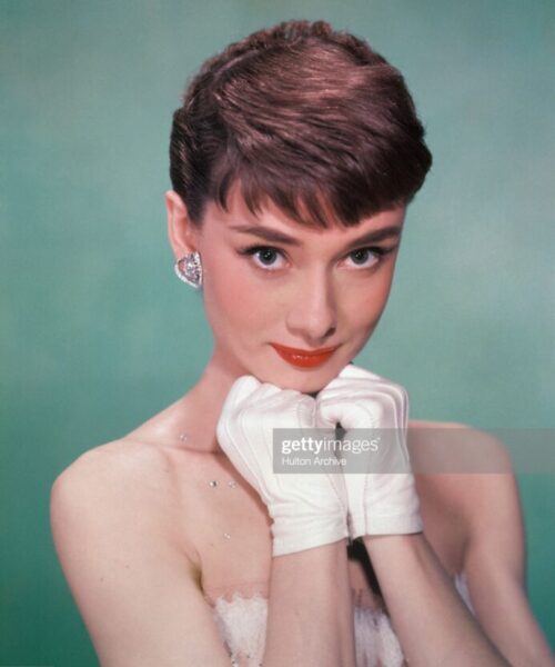 Portrait of Belgian-born American actress Audrey Hepburn (1929 - 1993) as she wears a strapless gown and holds white kid-gloved hands up to her chin, early 1950s. (Photo by Hulton Archive/Getty Images)